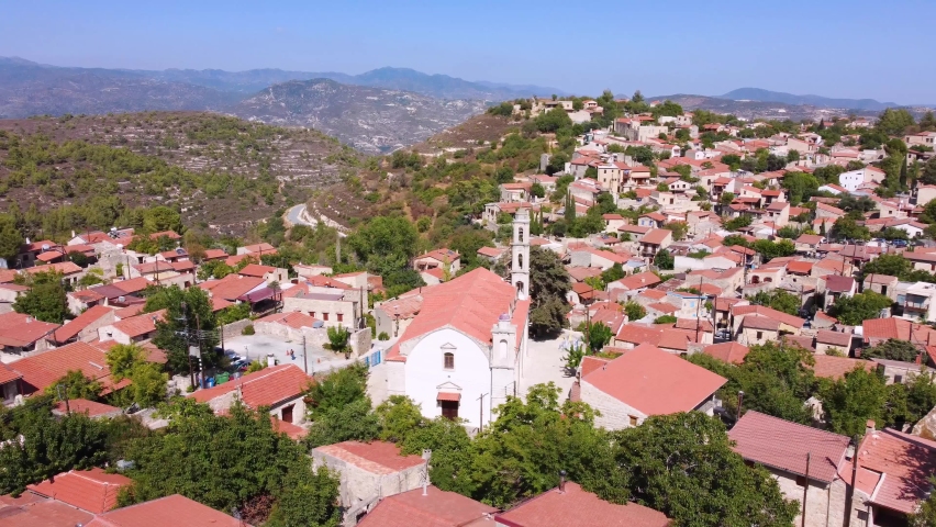 Aerial drone footage of traditional countryside village Lofou, in Limassol, Cyprus. 360 view of christian church Panayia Chrysolofitissa, ceramic tiled roof architecture and narrow streets from above.