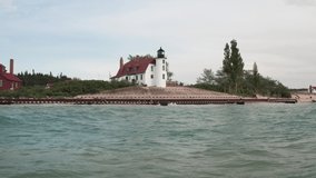 Historic Point Betsie Lighthouse in Frankfort, Michigan located along Lake Michigan with drone video low on water moving in.
