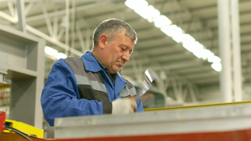 man shoots hammer in factory