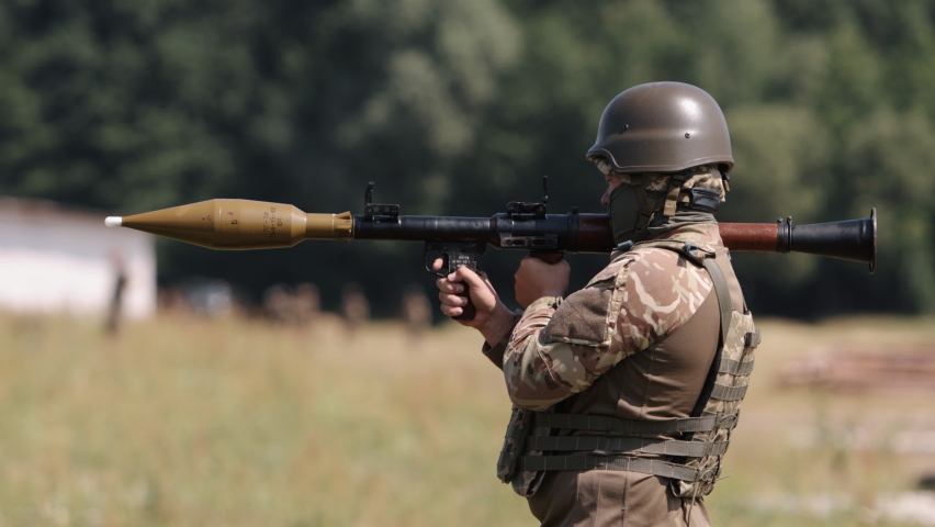Soldier in uniform, helmet, and body armor fire Precision Shoulder-Fired Rocket Launchers RPG-7 PSRL-1 at the enemies.