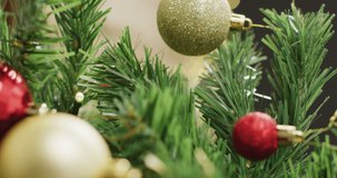 Vertical video of christmas tree with baubles on grey background. Christmas, tradition and celebration concept.