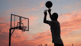 4k video Silhouettes of basketball players at the beautiful sunset. Amazing cinematic sport shoot. Two male playing street ball outside. - Powered by Shutterstock - Get 15% off with code: PIKWIZARD15