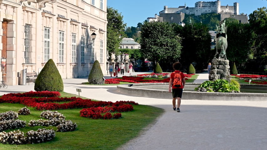 Salzburg, Austria, August 2022. Enchanting daytime footage of the Mirabell Palace Gardens. The tilt movement highlights the Hohensalzburg fort in the background.