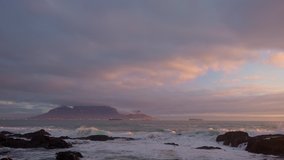  Iconic view across Table Bay of Table Mountain and Cape Town on a cloudy day at sunset from Bloubergstrand in the Western Cape. South Africa.