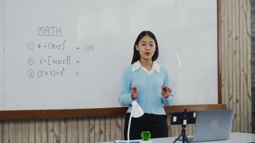 Teacher explaining the numbers on the board while video calling with students studying online. | Shutterstock HD Video #1094603133