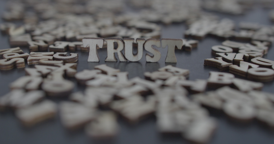 Trust word blown out, wooden alphabet letters on table, Relationship problems, Conceptual