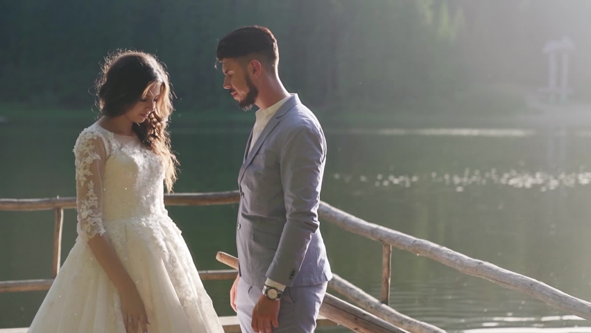 Couple of newlyweds kissing and hugging in the lake after their marriage.