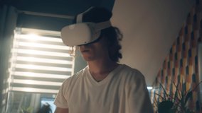 Man at home experiencing digital world and playing the video game using VR goggles and controllers. Virtual reality device. Cyberspace and metaverse