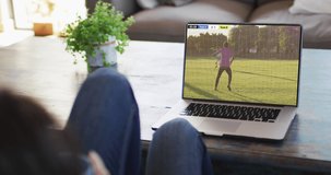 Man using laptop with diverse male soccer players playing match on screen. Global sport concept, digital composite video.
