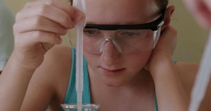 Animation of glowing lights over caucasian girl with pipette and chemistry beaker. Science and learning concept digitally generated video.