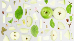 Green Apple fruit pieces, slices and leaves being moved upwards isolated on white. Top view, flat lay, seamless looping. High quality 4k video.