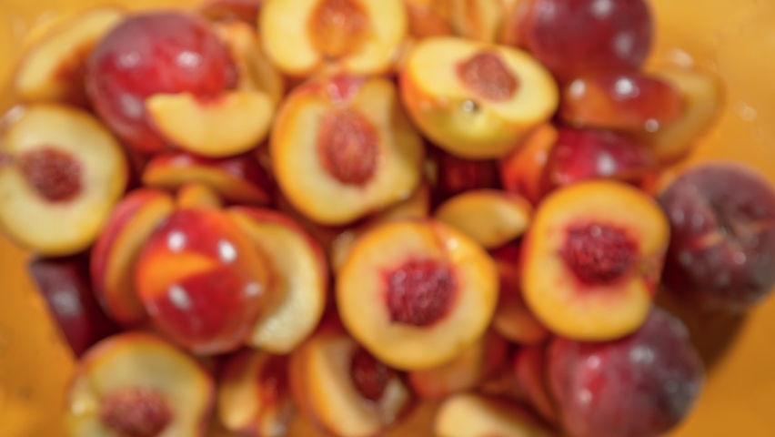 Super Slow Motion Shot of Peach Cuts And Water Flying Towards Camera on Orange at 1000 fps.