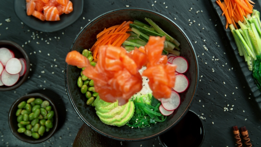 Super Slow Motion Shot of Fresh Salmon Cuts Falling into Poke Bowl at 1000fps. Royalty-Free Stock Footage #1094638079