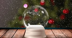 Animation of snow falling over snow globe with christmas tree. Christmas, winter and digital interface concept digitally generated video.