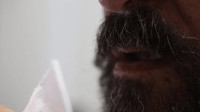 Bearded and mustache male wiping his mouth with a paper napkin. Body cleansing concept.