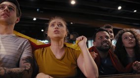 Group of friends cheering to soccer match in the pub. Shot with RED helium camera in 8K