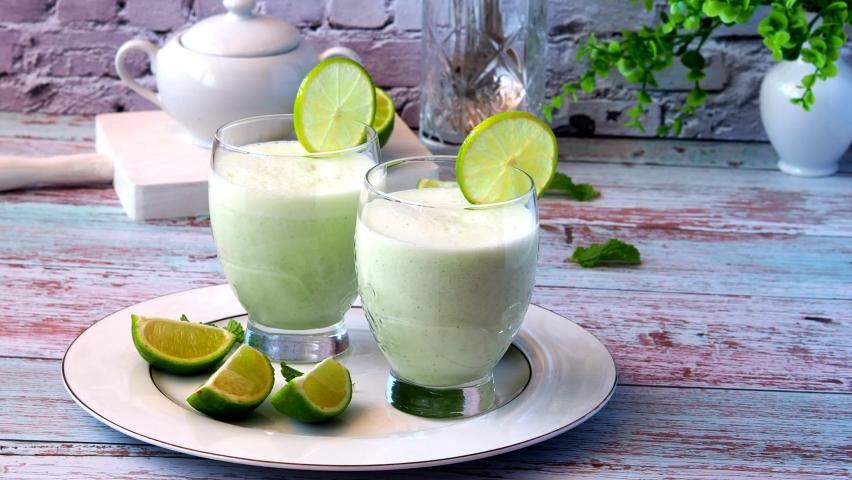 The bartender decorates a glass of Brazilian lemonade with a lime slice.