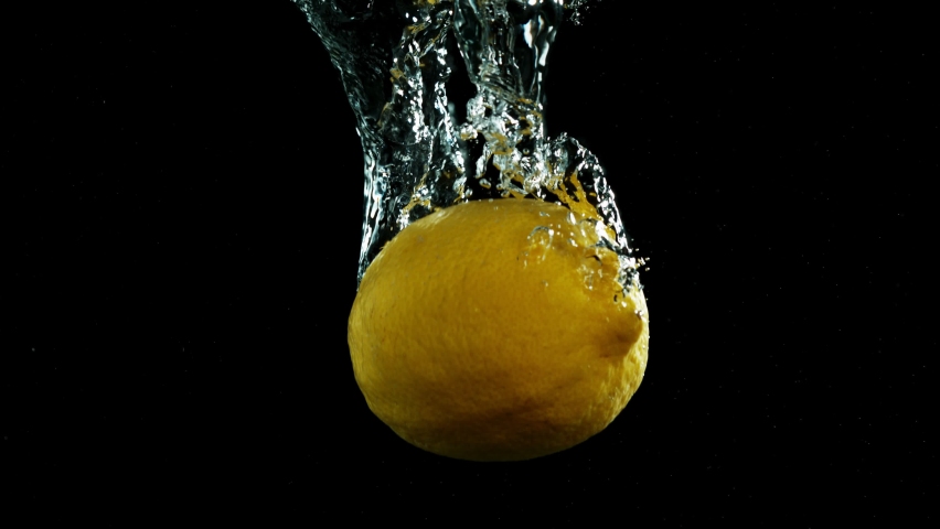 Super slow motion of falling lemon pieces isolated on black background. Filmed on high speed cinema camera, 1000 fps.