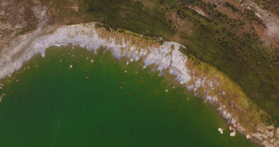 Salt at the waterfront of beautiful aquamarine waters. Circling over the bare shore of Mono Lake, California, USA at daytime.