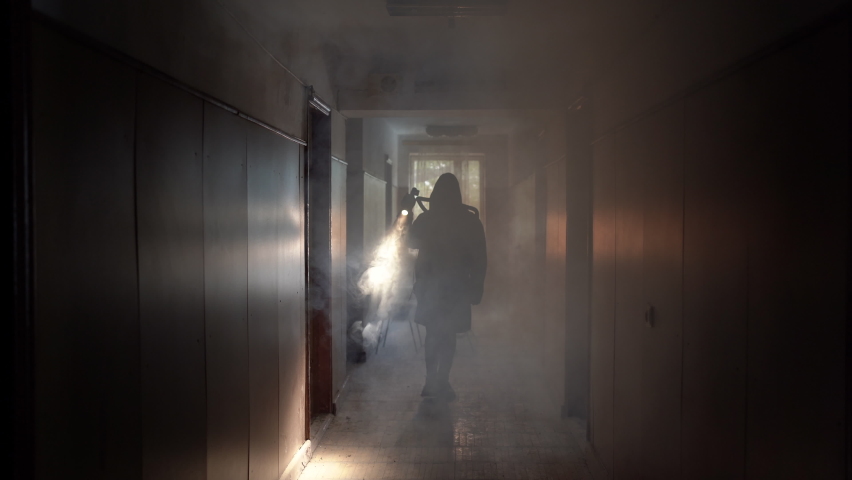 Woman in gas mask and cloak in smoke with flashlight an building at night, air pollution Royalty-Free Stock Footage #1094665969