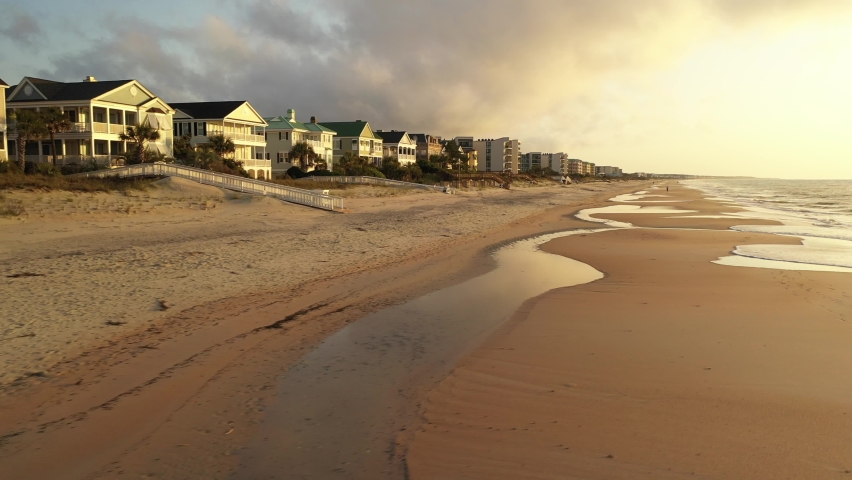 Golden sunrise shines on beach front homes at family vacation destination in coastal South Carolina