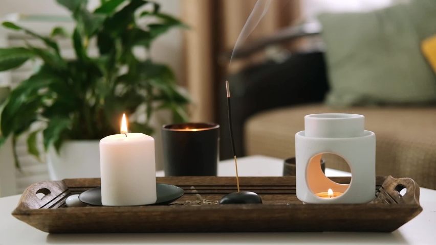 Burning scented candles and aroma incense stick, aroma lamp on table in living room. Aromatherapy, home fragrance. Concept of home relaxation and anti stress. | Shutterstock HD Video #1094669773