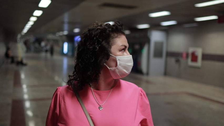A brunette woman in a white protective mask  | Shutterstock HD Video #1094674407