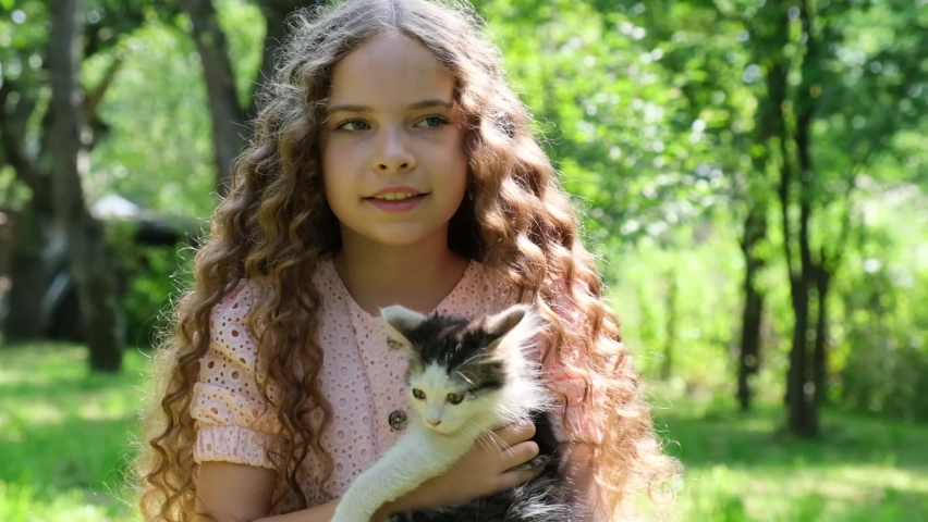 Cute curly girl with a cat in her arms. | Shutterstock HD Video #1094676897