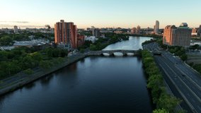 Aerial Drone Footage of the Charles River in Cambridge near Boston Massachusetts During Sunrise. Rowers and the city skyline visible on a beautiful summer morning. 