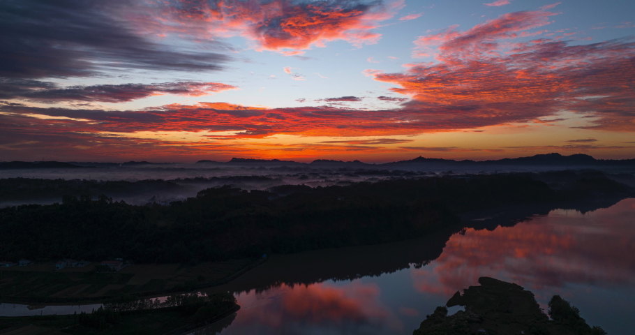 amazing beautiful sunrise aerial hyper lapse in the rural China with colorful clouds moving reflection in the river water