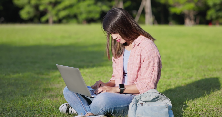 Asian college student feel frustrated while she having e-learning with laptop on legs in a park | Shutterstock HD Video #1094685375