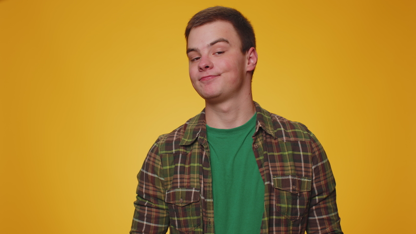Dislike. Upset unhappy handsome man in shirt showing thumbs down sign gesture, expressing discontent, disapproval, dissatisfied, dislike. Young adult guy boy. Indoor studio shot on yellow background | Shutterstock HD Video #1094687459