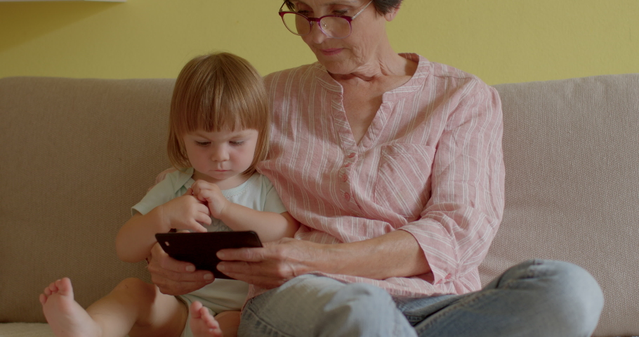 Mobile banking. Grandmother and granddaughter use smartphone. Impact of smartphones on different generations. Using smartphones as tools for lifelong learning older adults lifestyle healthy aging. Royalty-Free Stock Footage #1094693651
