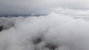 Aerial view low flight above the clouds in the mountains. Cloud video background screensaver