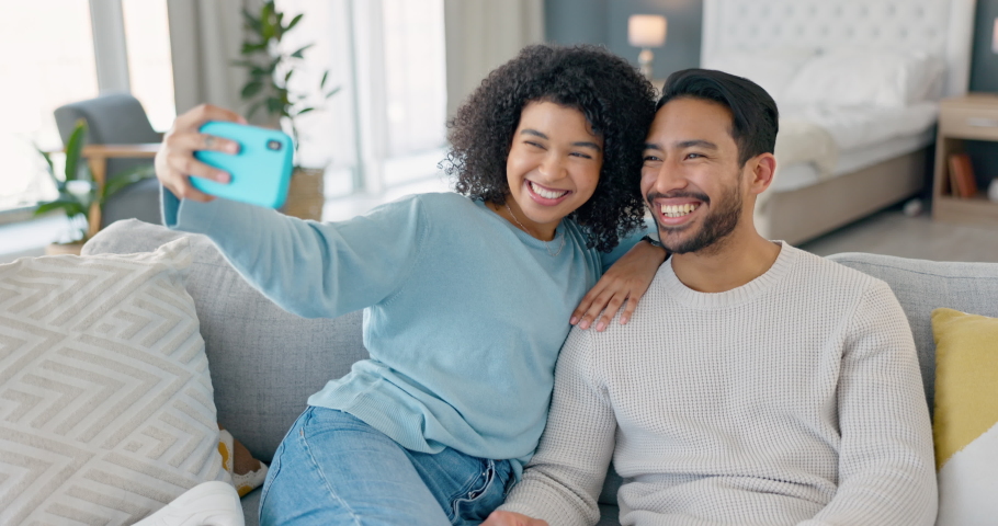 Happy couple, phone selfie and smile on living room sofa for love, relax and fun together. Young man, woman and people in relationship on lounge couch taking mobile photos for social media online | Shutterstock HD Video #1094697875