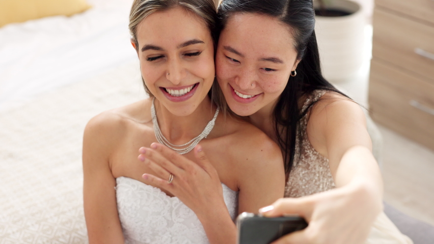 Friends, bride and bridesmaid smartphone selfie smile together for fun wedding photograph memory. Happy, joyful and cute women friendship with asian and caucasian woman looking at bridal pictures. | Shutterstock HD Video #1094698095