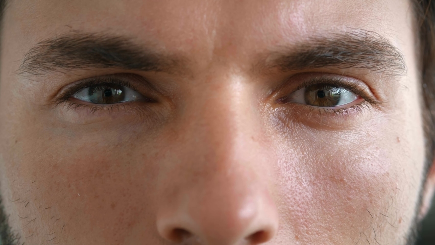 Cropped face portrait of a 30 years old male model, Caucasian man with mysterious gaze and powerful brown eyes, looking mysteriously at the camera. The window to the soul | Shutterstock HD Video #1094708633