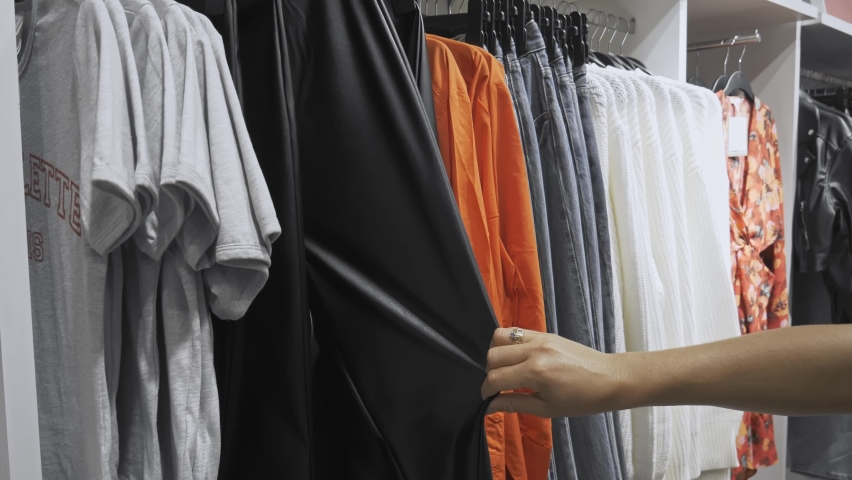 Close-up of female hands plucked hanger Women choosing clothes in a clothing store. woman hand runs across a rack of clothes. Sale Promotion and Shopping Concept. | Shutterstock HD Video #1094711411