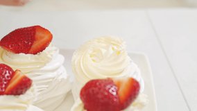 close up. cook decorates cakes anna pavlova with strawberries. recipes for delicious traditional desserts. cooking school and courses. confectionery menu