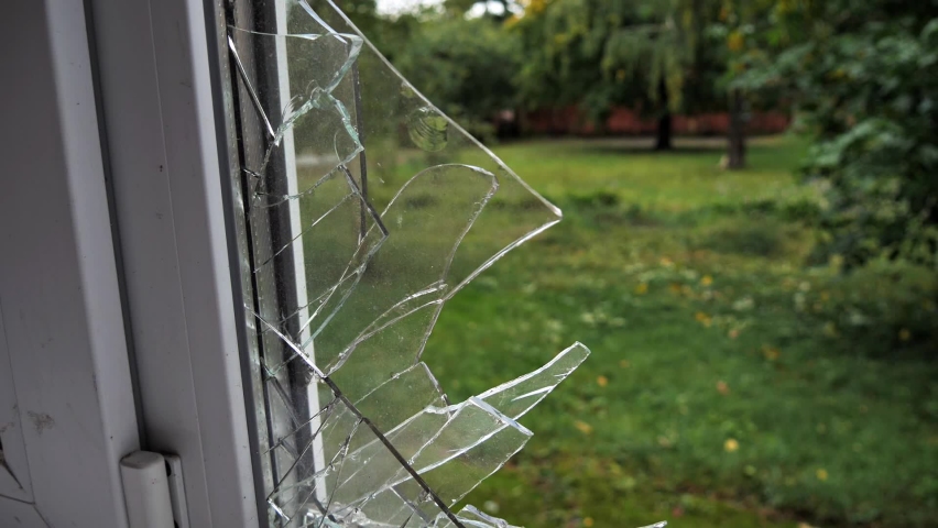 View outside through broken glass window. Large shards of glass in a broken window. | Shutterstock HD Video #1094712249