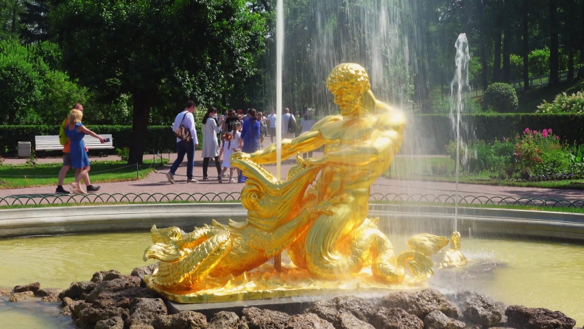 Gold sculpture Samson and Lion fountain in Peterhof, Russia . Decoration of park museum monument on sunny summer day against background of tourists, passersby. Symbol of victory in battle of Poltava
