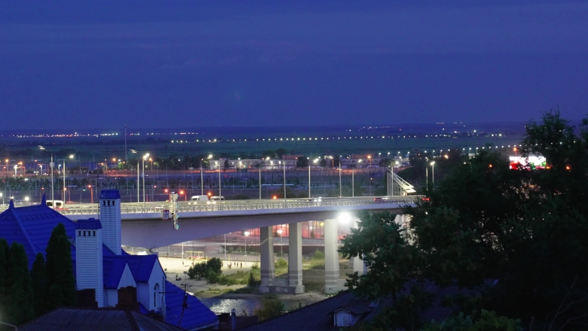 time laps. night. accelerated shooting of the movement of cars on the road bridge over the river. car traffic in the city. Cityscape.