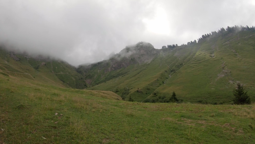 Serene alpine landscape of mountain summits hidden in clouds, Brienz Switzerland