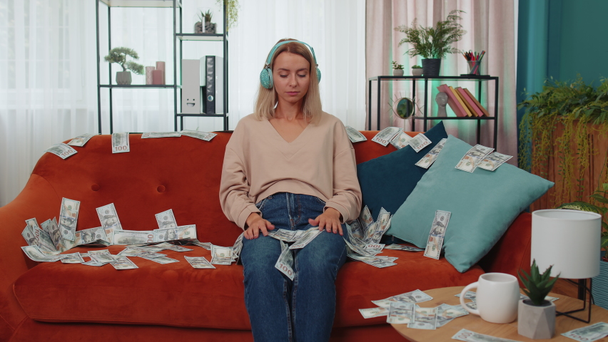 Successful happy rich business woman girl counting money cheering up with high profits, lottery game win, satisfied of wealth income earnings salary, on home room couch full of dollar cash banknotes | Shutterstock HD Video #1094727051