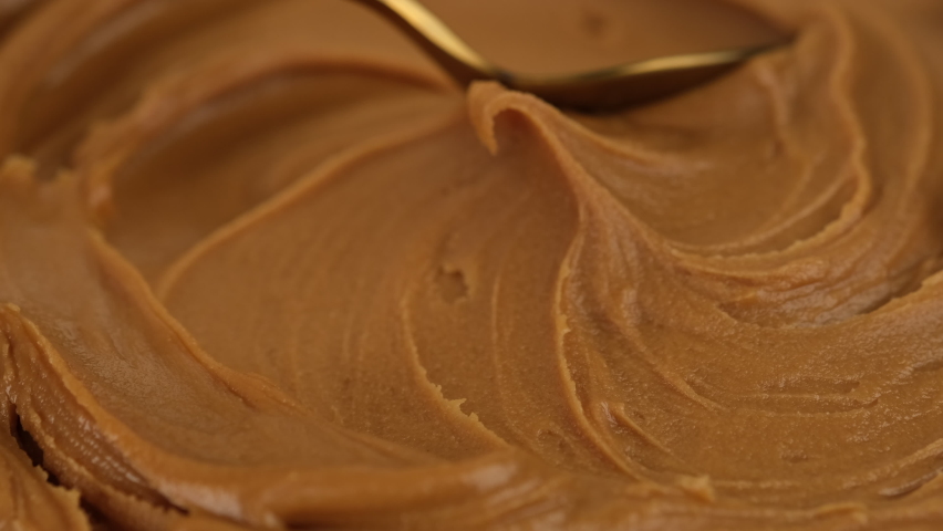Classic peanut butter. Stir peanut butter with golden spoon before eating on breakfast Royalty-Free Stock Footage #1094727969