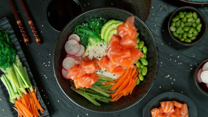 Super Slow Motion Shot of Fresh Salmon Cuts Falling into Poke Bowl at 1000fps. Royalty-Free Stock Footage #1094730147