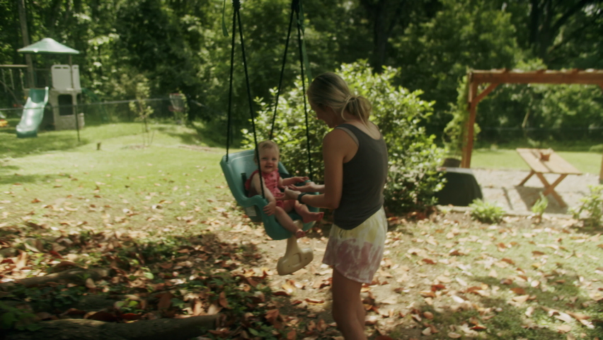 Mother pushing baby on a swing | Shutterstock HD Video #1094732083