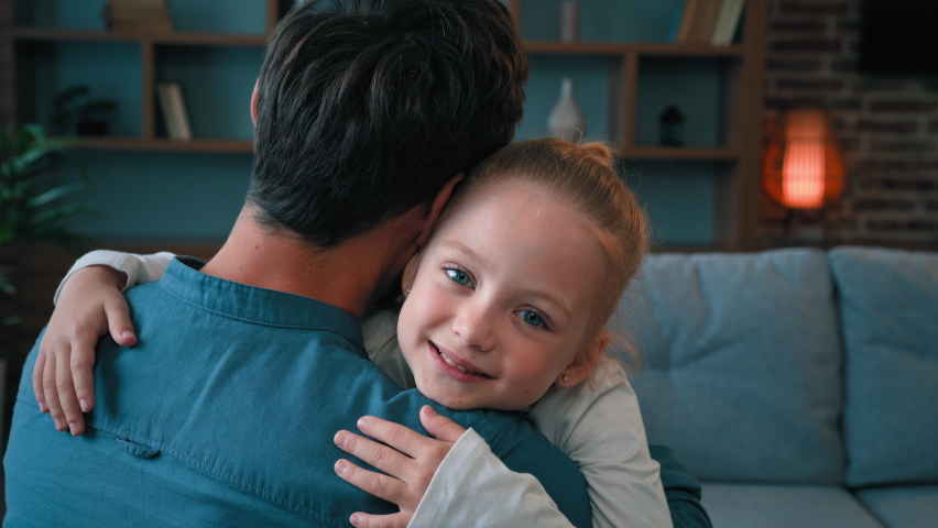 Loving cute daughter hugging adorable daddy happy young caucasian family single father embracing little child girl at home on Father's day parental love tenderness emotions relaxing together on sofa | Shutterstock HD Video #1094733601