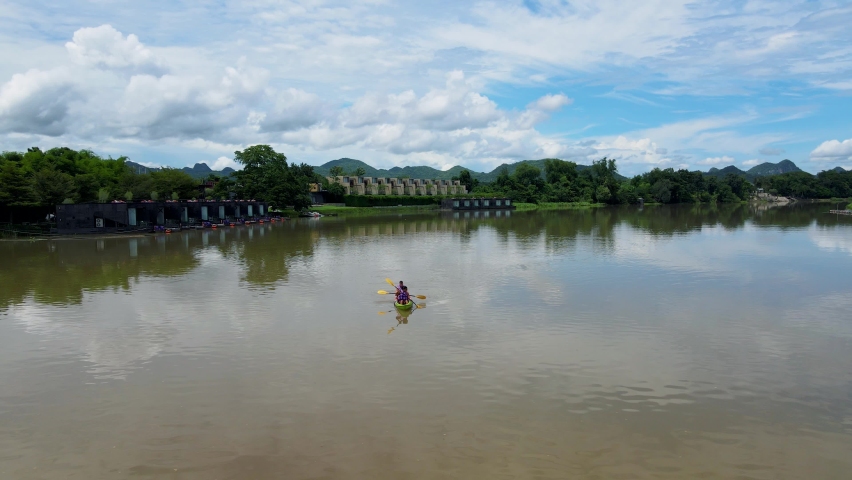 A couple of men and women in kayak on the River Kwai in Thailand. men and women peddling in a kayak on the river in Thailand