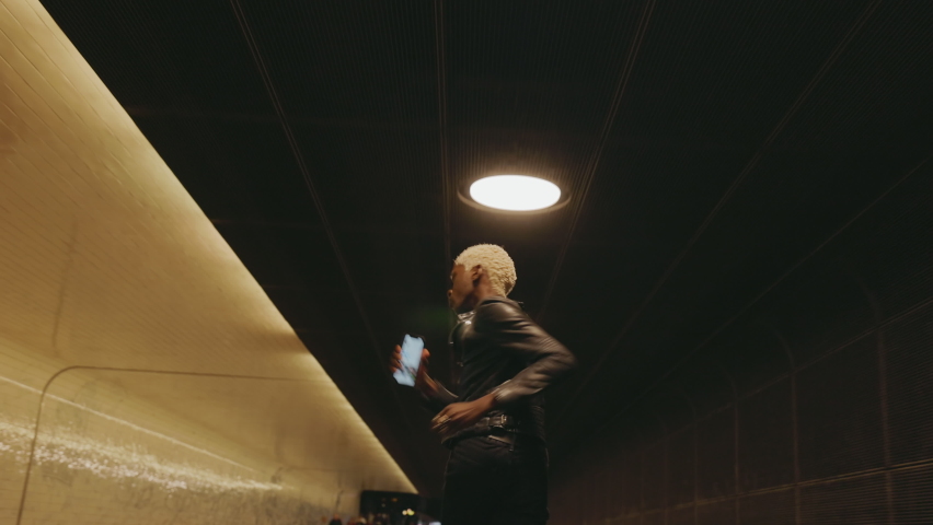 Stylish Black Guy In Leather jacket Is Running With Phone In His Hands.